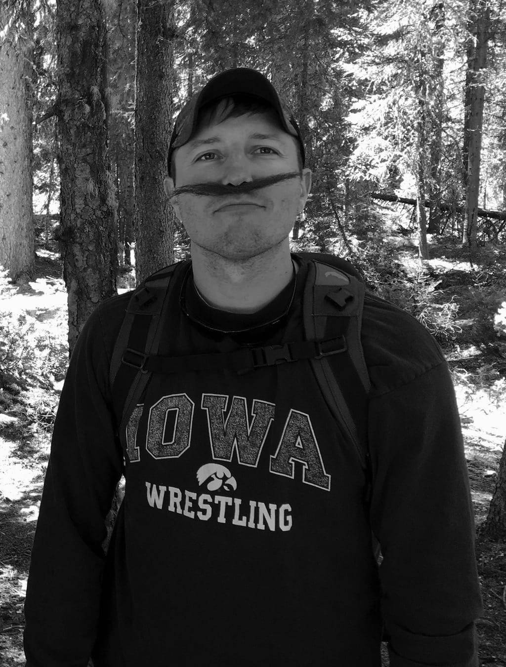 Luke in a pine forest, sporting a handlebar mustache